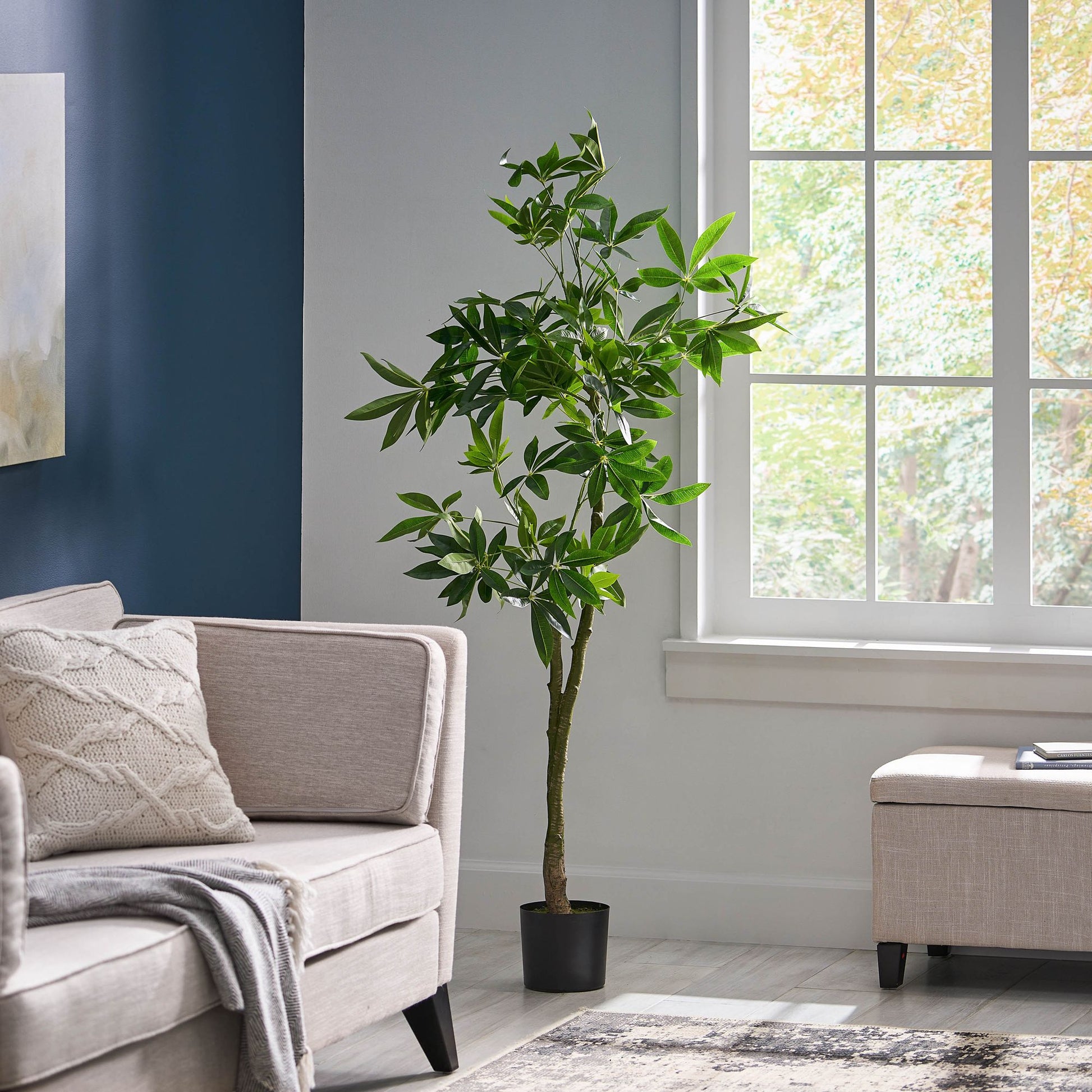 Faux artificial money tree decor in a modern living room setting with natural light