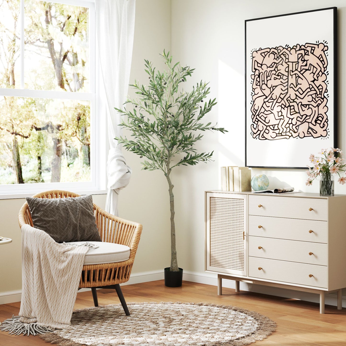 Artificial olive tree indoor in black pot next to wicker chair and white cabinet in bright living room