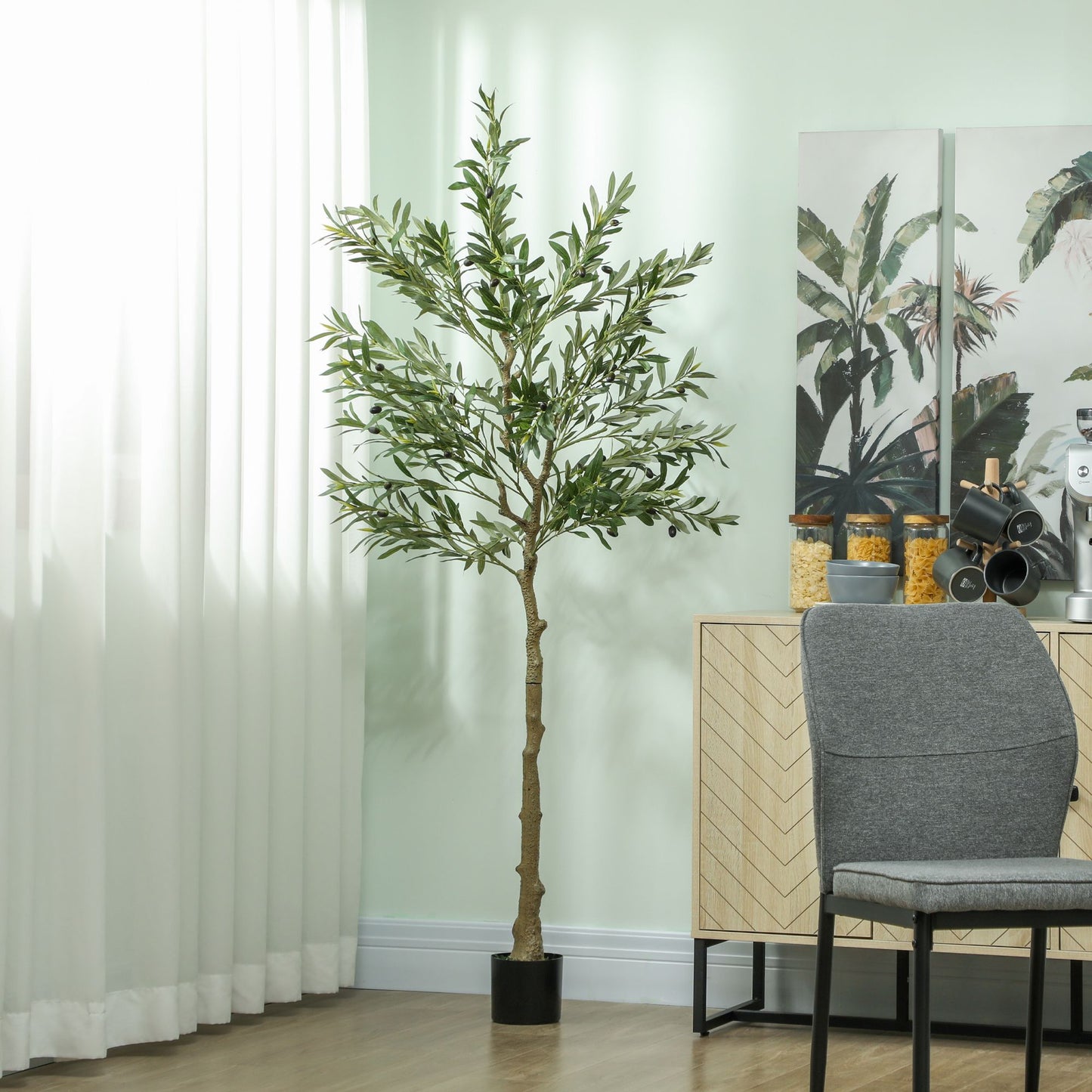 Artificial olive tree indoor with realistic green leaves in a black pot placed in modern living room
