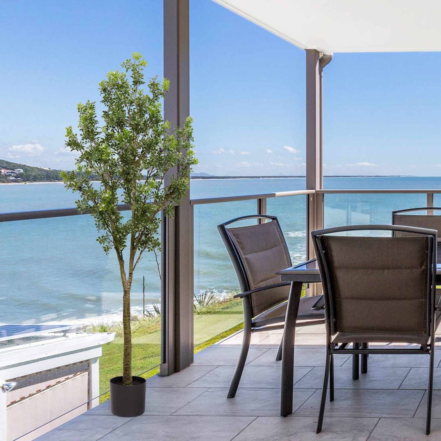 Artificial outdoor garden branches in a potted tree adding greenery to a modern balcony with ocean view