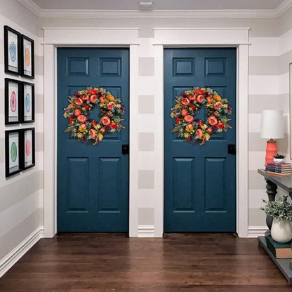 Artificial flower door wreath hanging on two blue interior doors with colorful floral arrangement
