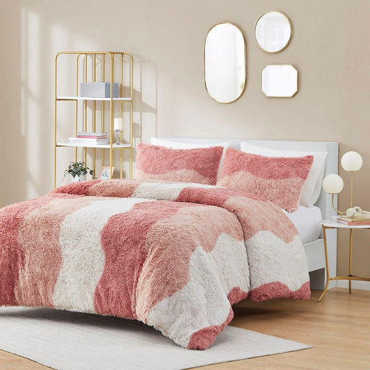 Ombre faux fur comforter set in shades of pink and white on bed in modern bedroom