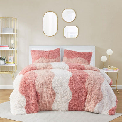 Ombre faux fur comforter set in shades of pink and white with matching pillow shams on bed
