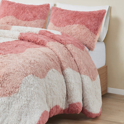 Ombre faux fur comforter set in shades of pink and white on a neatly made bed