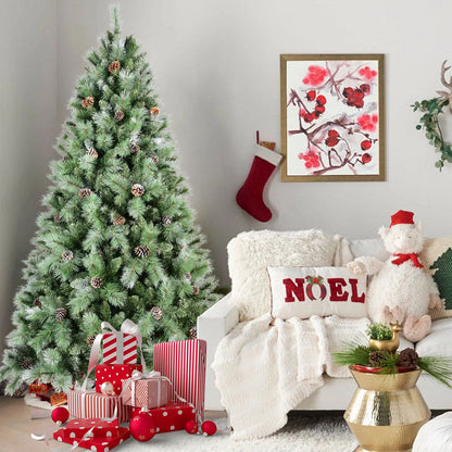 Frosted artificial Christmas tree decorated with pine cones next to wrapped presents in a cozy living room