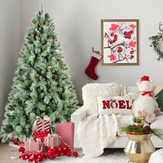 Frosted artificial Christmas tree decorated with pine cones next to wrapped presents in a cozy living room