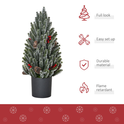 Miniature snow flocked Christmas tree with pinecones and red berries in a black pot