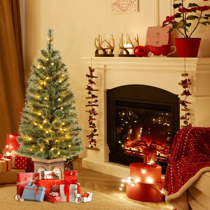 Pre-lit artificial Christmas tree decorated with lights in a cozy living room setting
