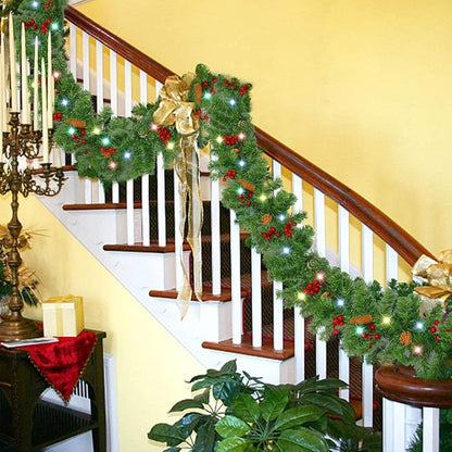 Prelit artificial Christmas garland decorated with red berries and bows on a staircase railing