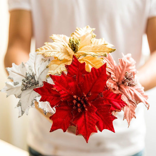Person holding glittery red white gold poinsettia flowers Christmas decoration for festive decor