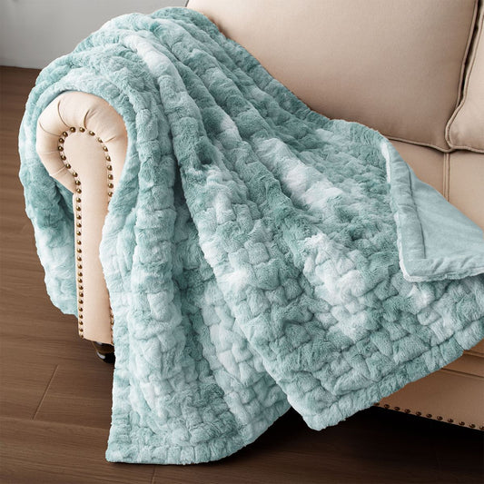Soft blue ruched faux fur throw blanket draped over beige couch armrest