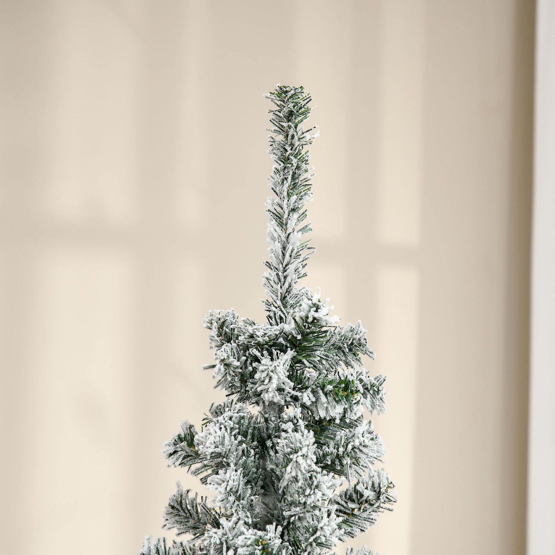 6 foot snow flocked Christmas tree with lush green branches covered in white snow for holiday decor