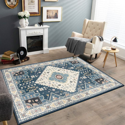 Blue and white patterned faux wool area rugs in a modern living room with cushioned chair and decorative fireplace