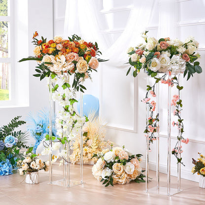Elegant acrylic wedding flower stands holding lush floral arrangements with roses and greenery