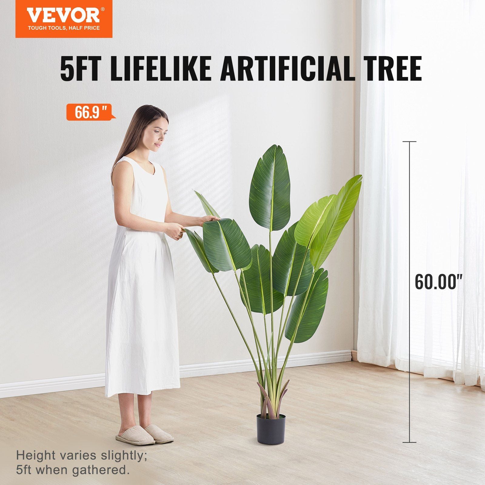 5ft lifelike artificial birds of paradise tree with large green leaves in black pot next to woman