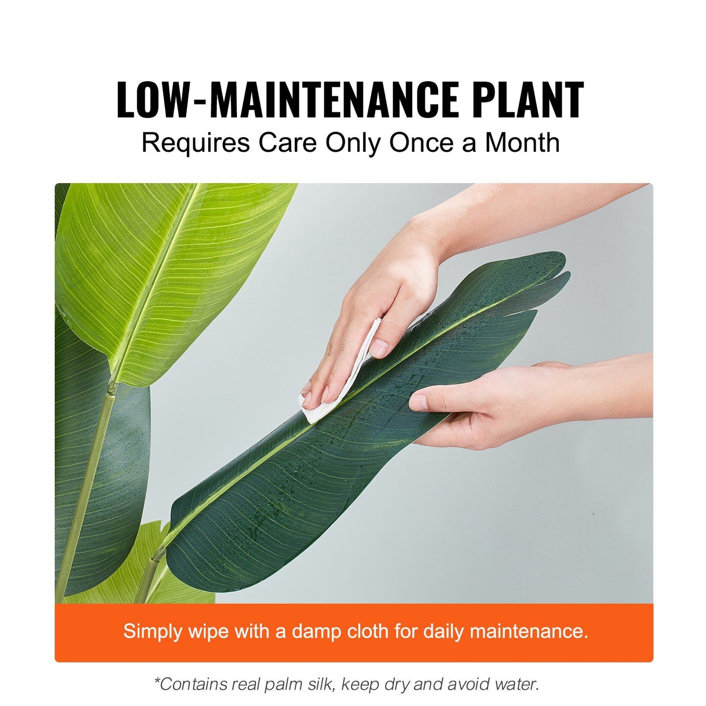Person wiping large green leaf of artificial birds of paradise tree for low maintenance care
