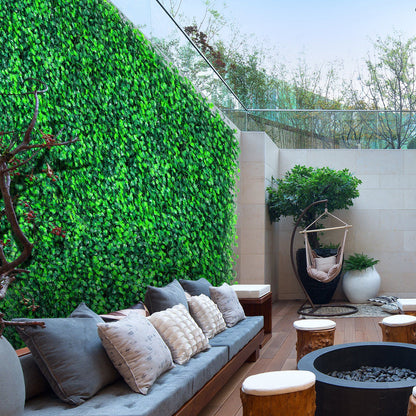 Outdoor seating area with artificial boxwood hedge panels covering the wall for privacy and greenery