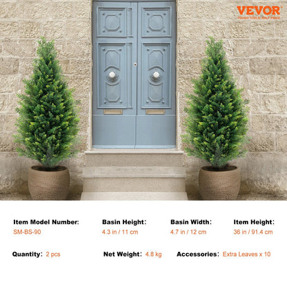 Pair of artificial cedar topiary trees in pots placed on either side of a gray front door