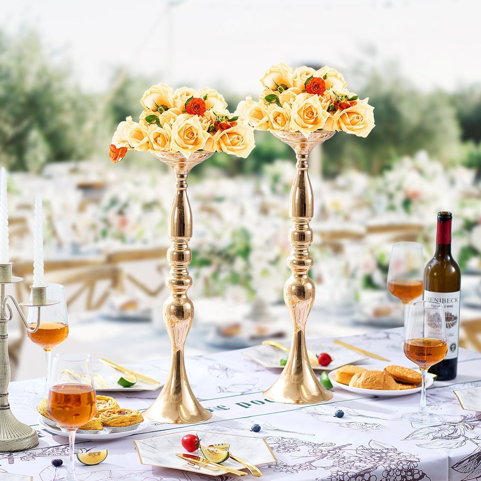 Elegant gold wedding flower stands holding cream and orange rose bouquets on a decorated table